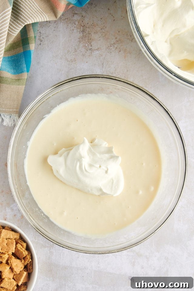 Overhead view of whipped cream added to cheesecake mixture