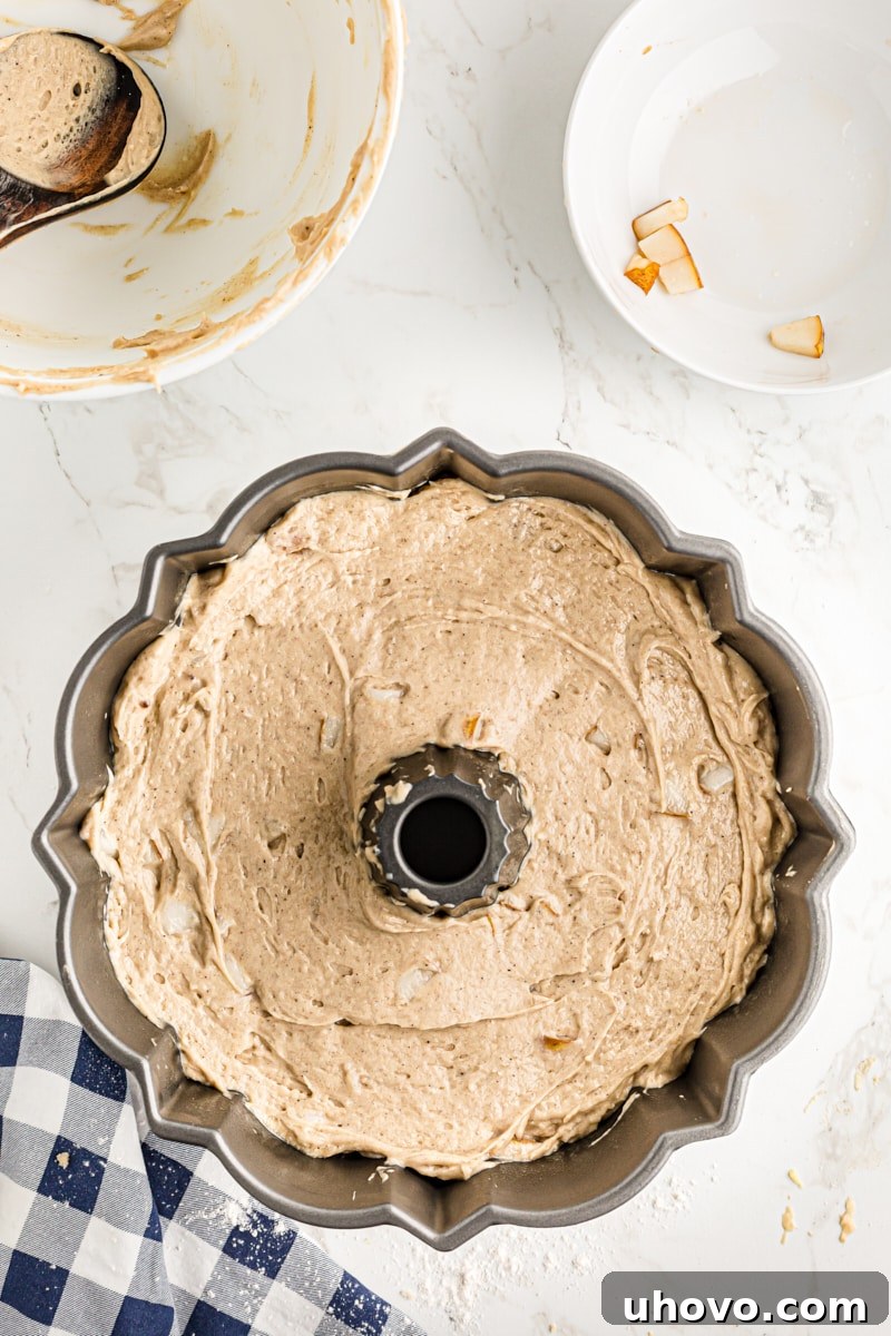 Spiced pear cake batter in the prepared bundt cake pan.