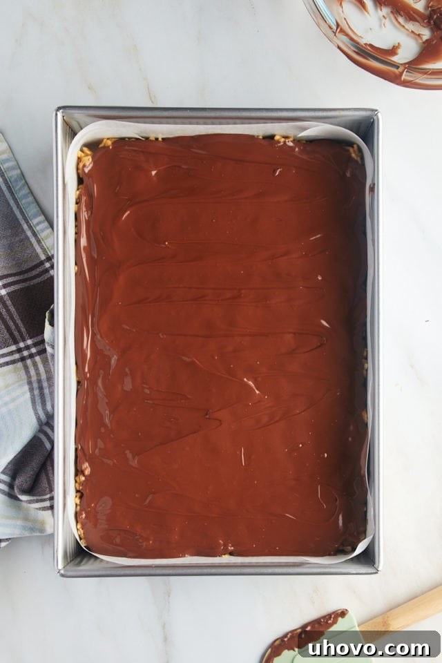 Overhead view of scotcheroos in pan, with the topping smoothly spread.