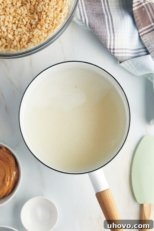 Overhead view of syrup mixture in saucepan, gently simmering.