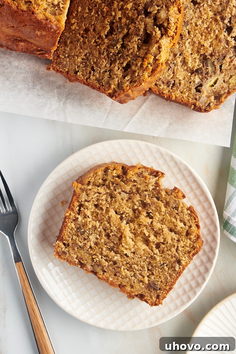 A single, perfectly sliced piece of peanut butter banana bread resting invitingly on a simple white plate, ready to be enjoyed.