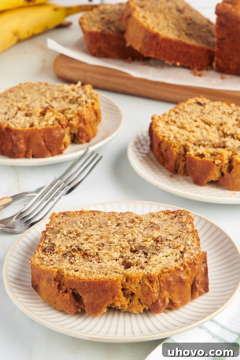 A generous display of peanut butter banana bread, with whole slices arranged on white plates and a cutting board, showcasing its appeal.