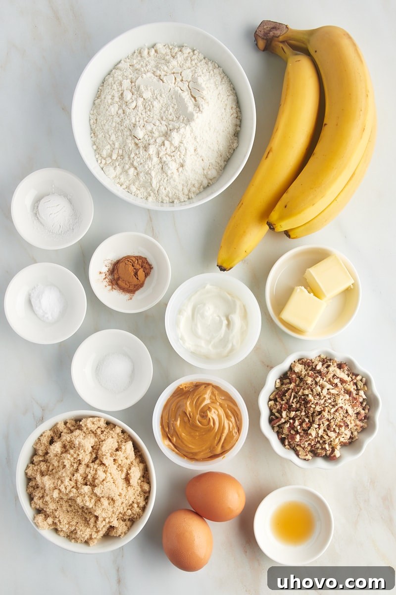 Overhead view of all the fresh ingredients neatly laid out on a clean counter, ready for preparing peanut butter banana bread.
