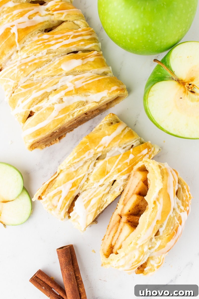 Overhead view of a beautifully sliced apple strudel resting on a elegant marble surface, showcasing its layers and filling.