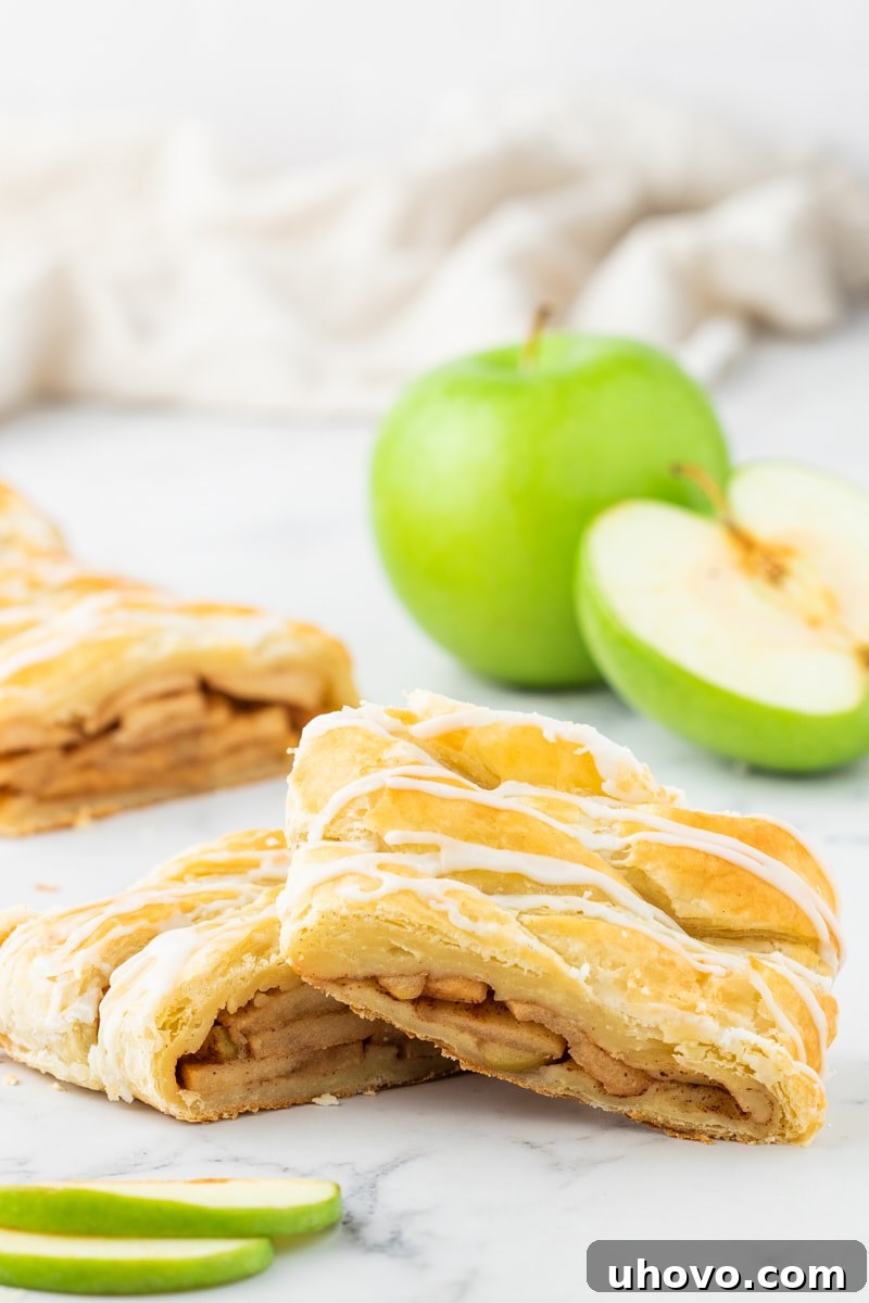 Two exquisite slices of apple strudel presented beautifully on a marble surface, inviting a taste of its delicious layers.