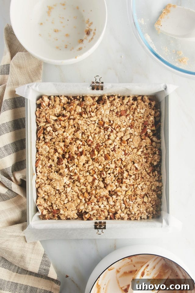 Overhead view of unbaked date bars in the pan, topped with the crumbly nut mixture, ready for the oven.