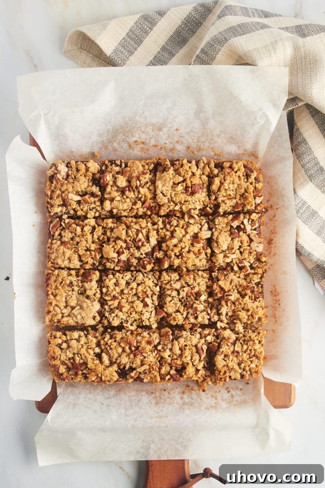Overhead view of beautifully cut date bars arranged on a parchment-lined cutting board.