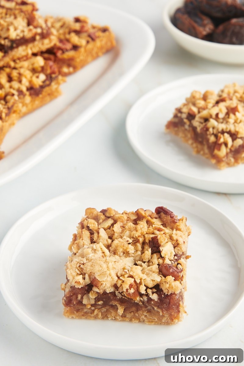 Two plates of date bars in the foreground, with an additional platter of bars softened in the background, showcasing different serving styles.