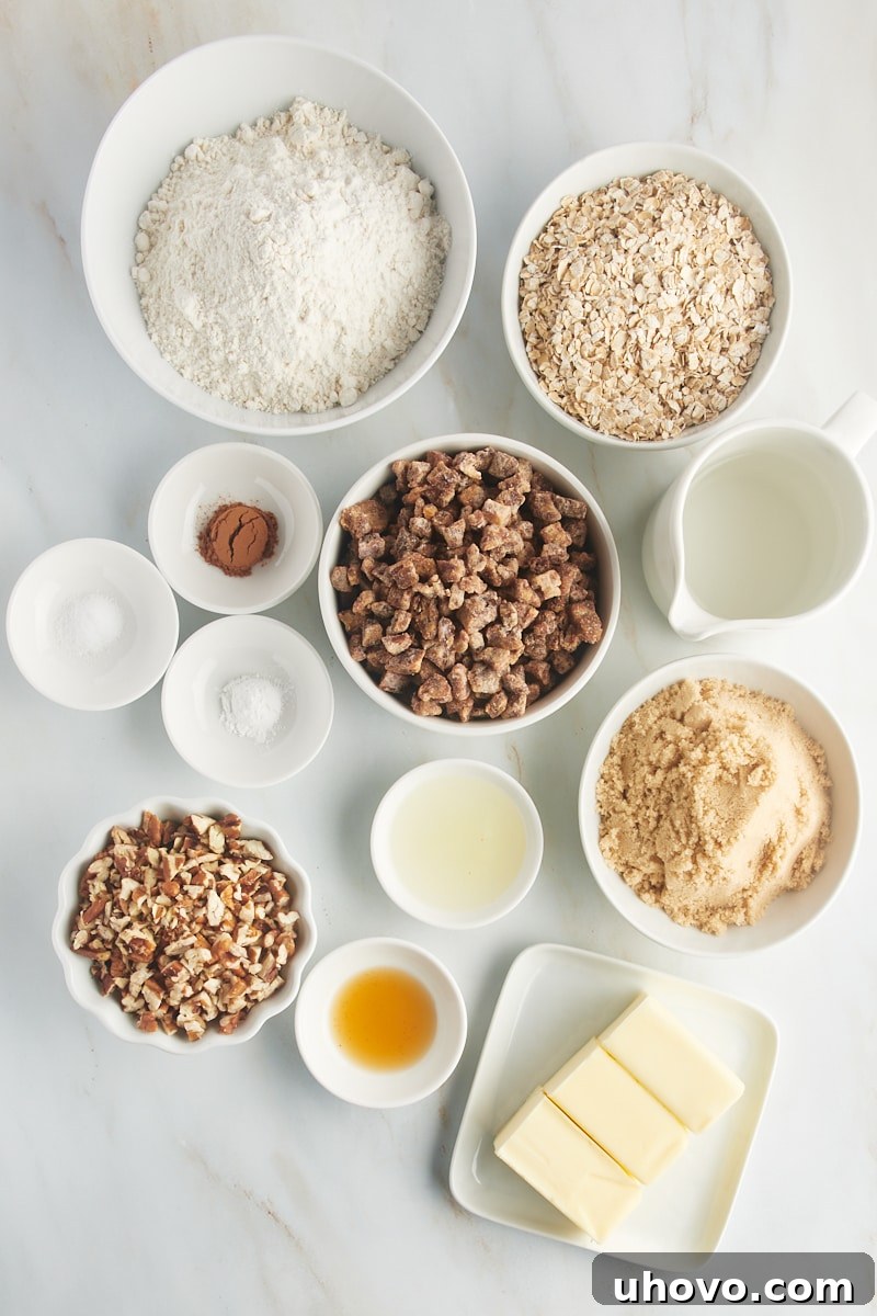Overhead view of all ingredients for easy date bars laid out on a white surface, including chopped dates, oats, flour, butter, and spices.