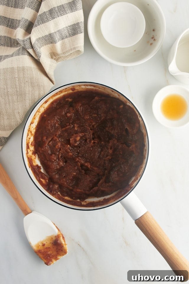 Overhead view of date filling simmering in a saucepan on the stovetop, thickening beautifully.