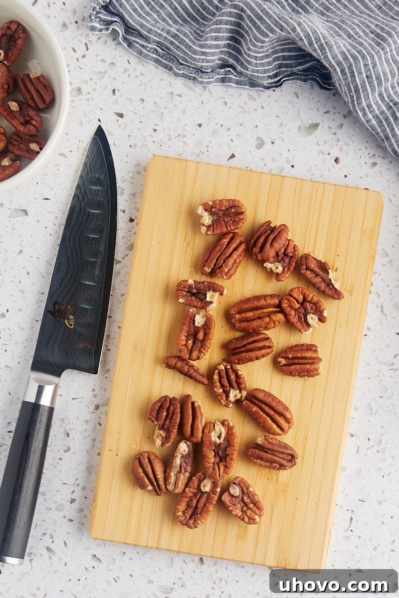 overhead view of toasted pecans on a wooden cutting board