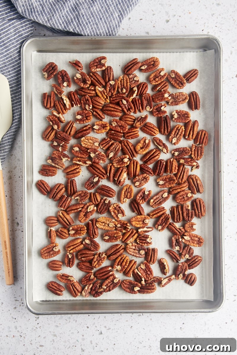 overhead view of toasted pecans on a parchment-lined baking sheet