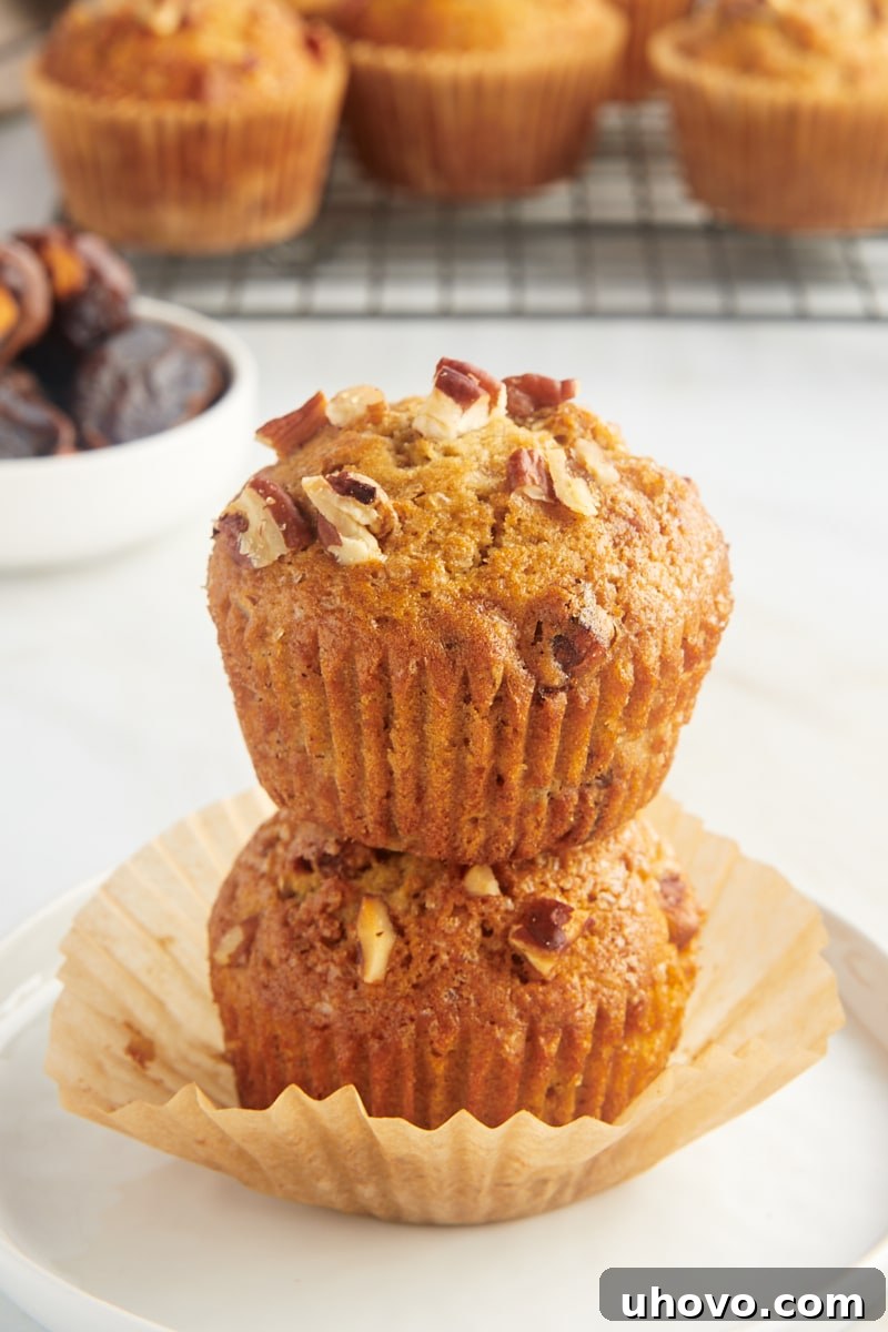 two stacked date nut muffins on a white plate