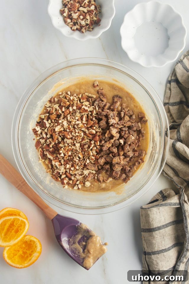 overhead view of dates and nuts added to muffin batter in a glass mixing bowl