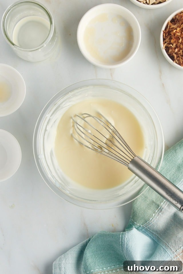 An overhead view of the smoothly mixed glaze for the Louisiana Crunch Cake, showcasing its creamy consistency in a glass mixing bowl, ready to be applied.