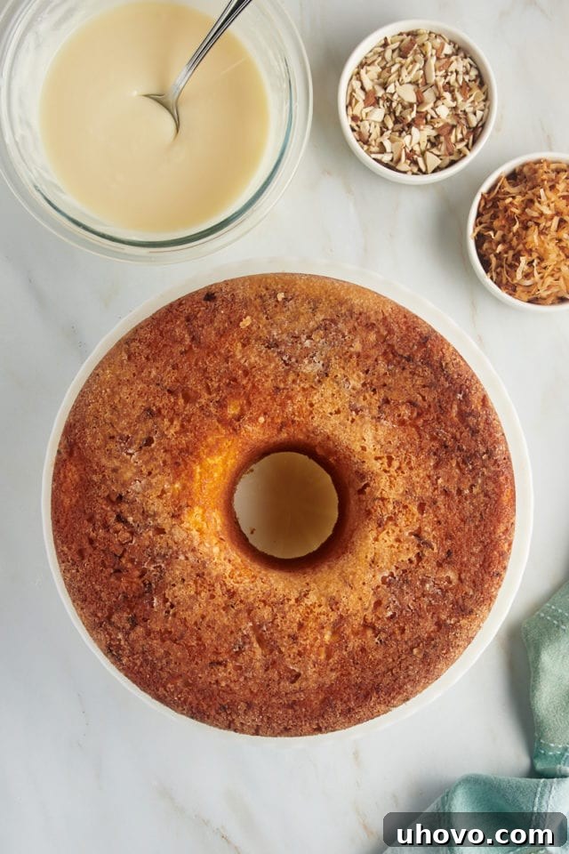 An overhead view of the freshly baked and cooled Louisiana Crunch Cake, beautifully unmolded and resting on a white cake plate, ready for its glaze.