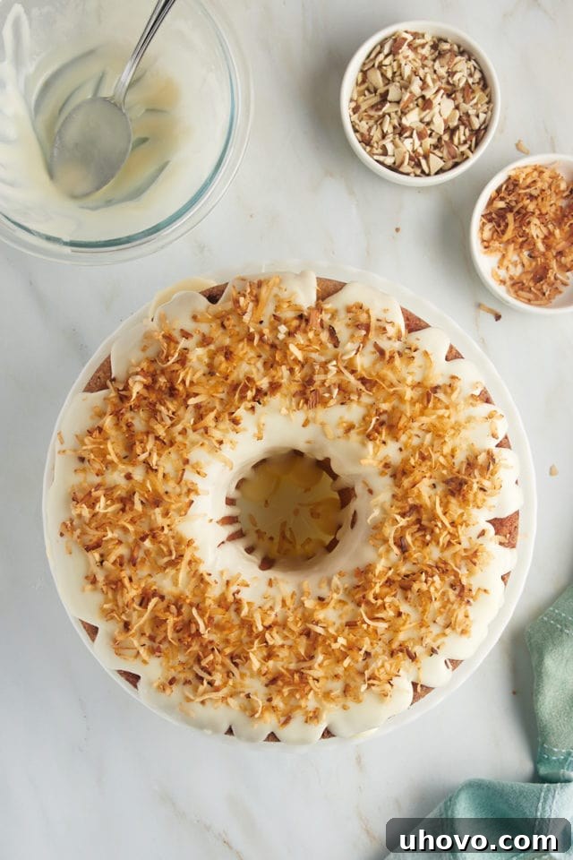 An overhead view of the Louisiana Crunch Cake, fully glazed and now topped with a generous layer of perfectly toasted coconut, adding both flavor and texture.