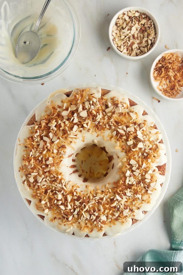 The finished Louisiana Crunch Cake, presented from an overhead view, adorned with its sweet glaze, toasted coconut, and a final flourish of chopped almonds, creating an irresistible dessert.