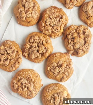 overhead view of crumb-topped apple cookies on a sheet of parchment paper