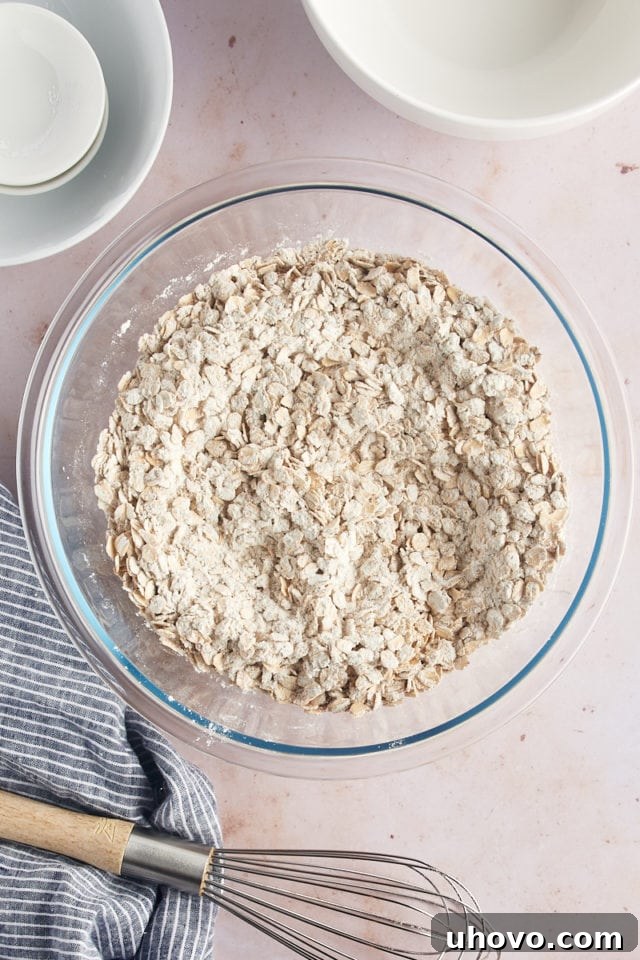 Overhead view of dry ingredients and oats in glass bowl