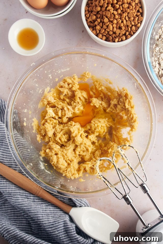 Overhead view of eggs added to wet ingredients for oatmeal butterscotch cookies