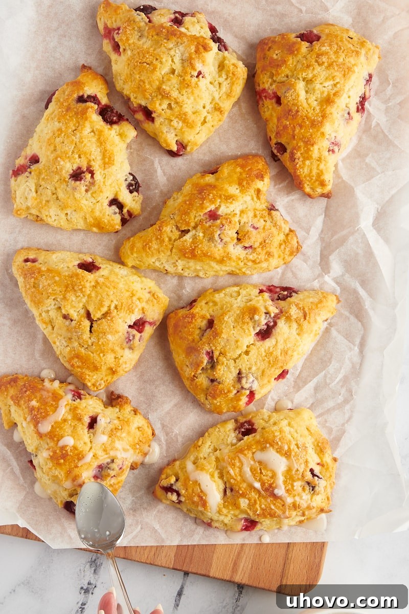 overhead view of a sweet orange glaze being drizzled over cranberry orange scones