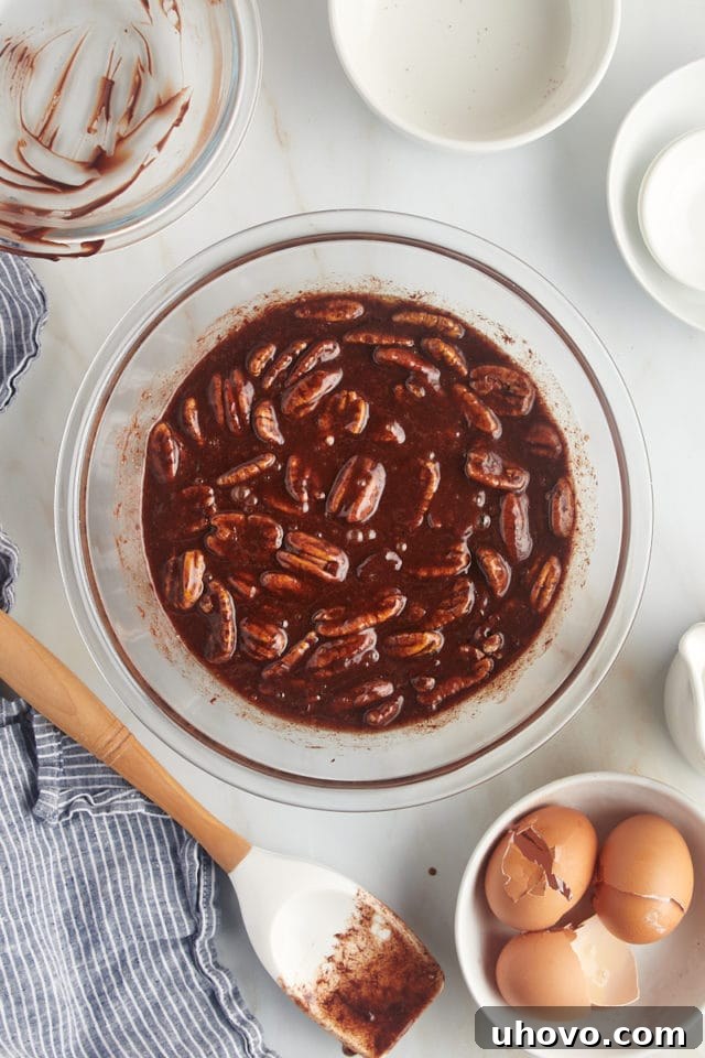 overhead view of mixed chocolate pecan pie filling in a glass bowl
