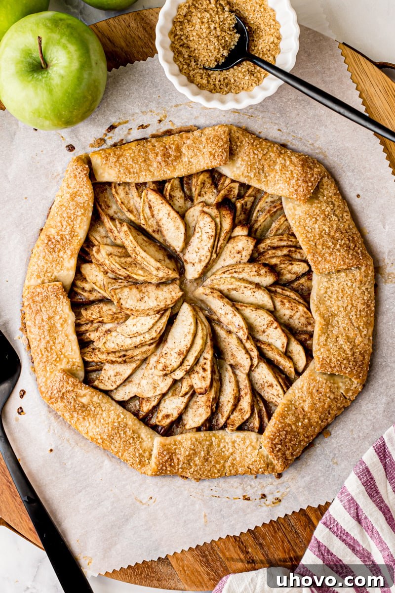 overhead view of apple galette on parchment paper on a wooden board