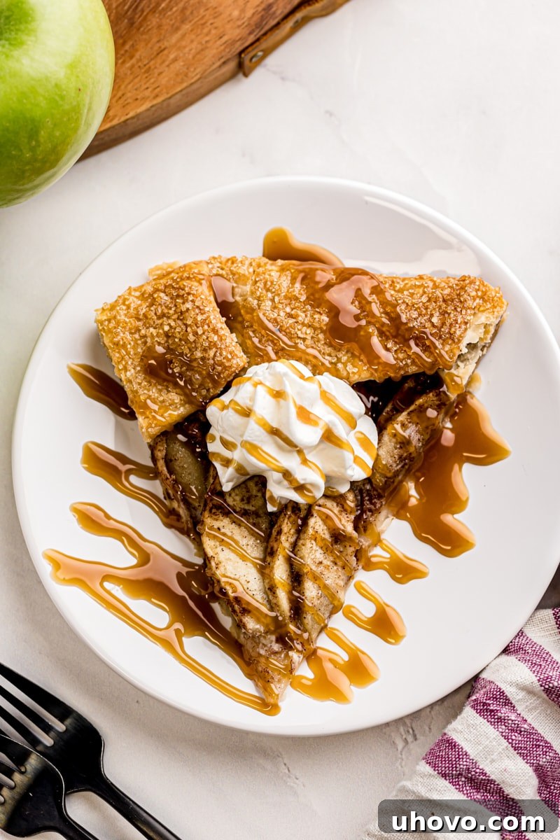 overhead view of a slice of apple galette topped with whipped cream and caramel sauce