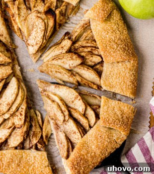 overhead view of a partially sliced apple galette on parchment paper