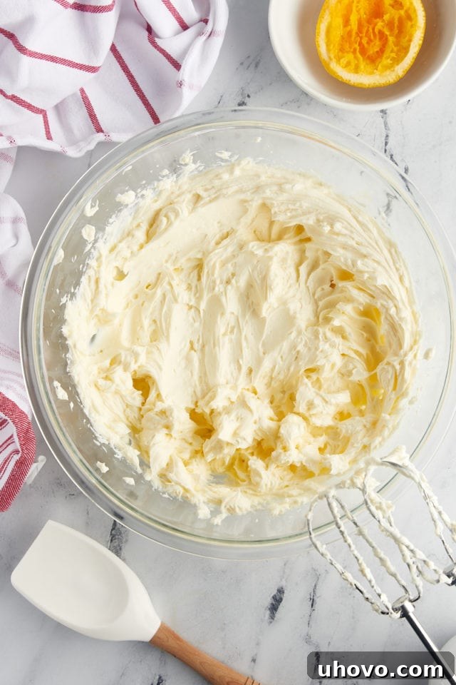overhead view of beaten cream cheese, sugar, and orange juice in a mixing bowl