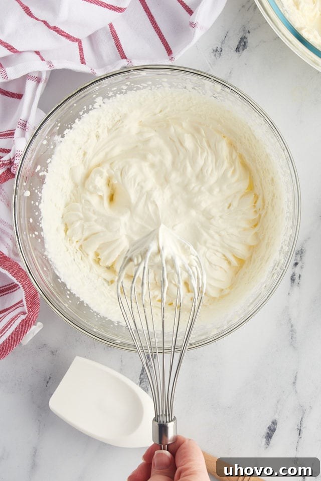 overhead view of heavy cream whipped to stiff peaks in a glass mixing bowl