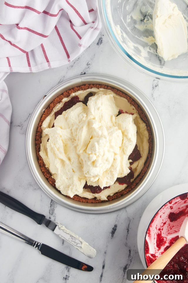 overhead view of remaining cheesecake filling added to no-bake cranberry cheesecake