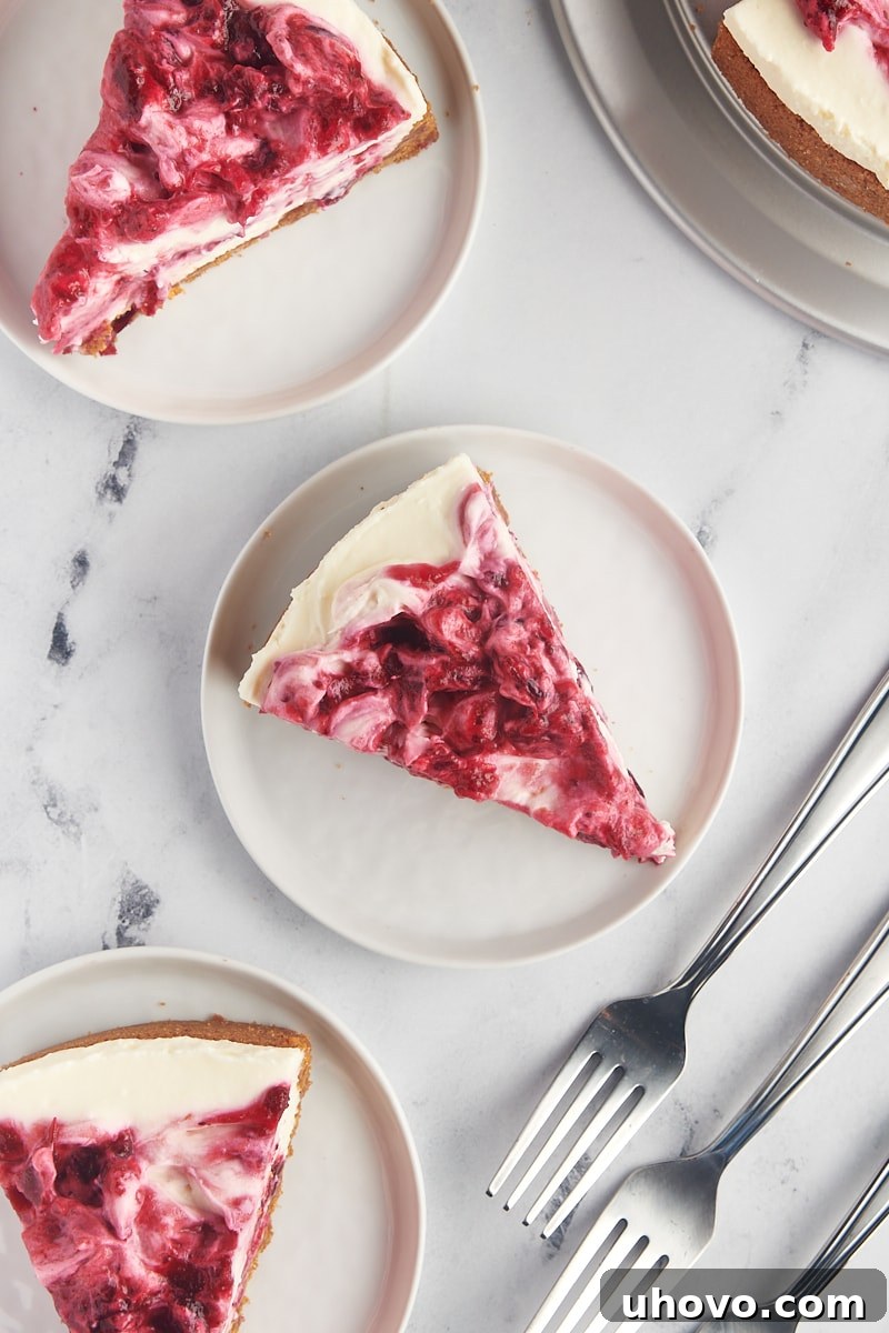 overhead view of three slices of no-bake cranberry cheesecake on white plates