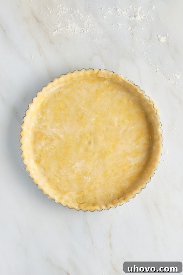 Overhead view of the pastry crust carefully fitted into a 9-inch tart pan with a removable bottom.