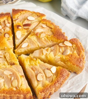 Whole pear frangipane tart on parchment-lined board