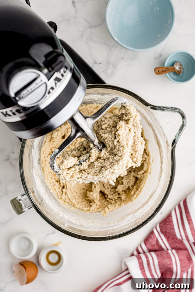 An overhead view of perfectly mixed spritz cookie dough in the bowl of a stand mixer, smooth and ready for the cookie press.
