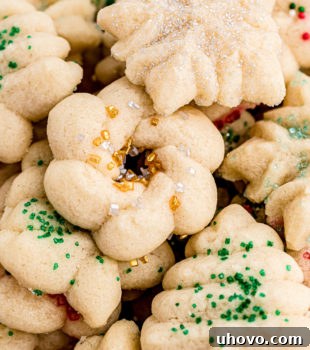 An overhead view of numerous Christmas spritz cookies piled together, showcasing their festive decorations.