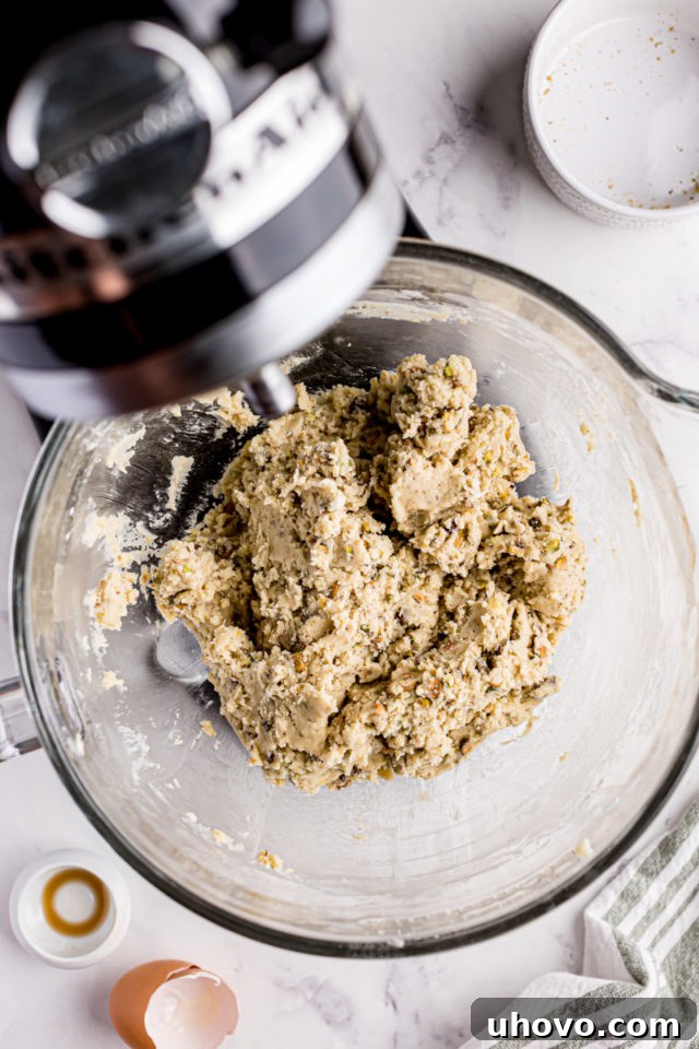 overhead view of mixed pistachio cookie dough in the bowl of a stand mixer