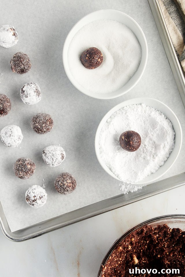overhead view of bourbon balls being rolled in granulated sugar and powdered sugar