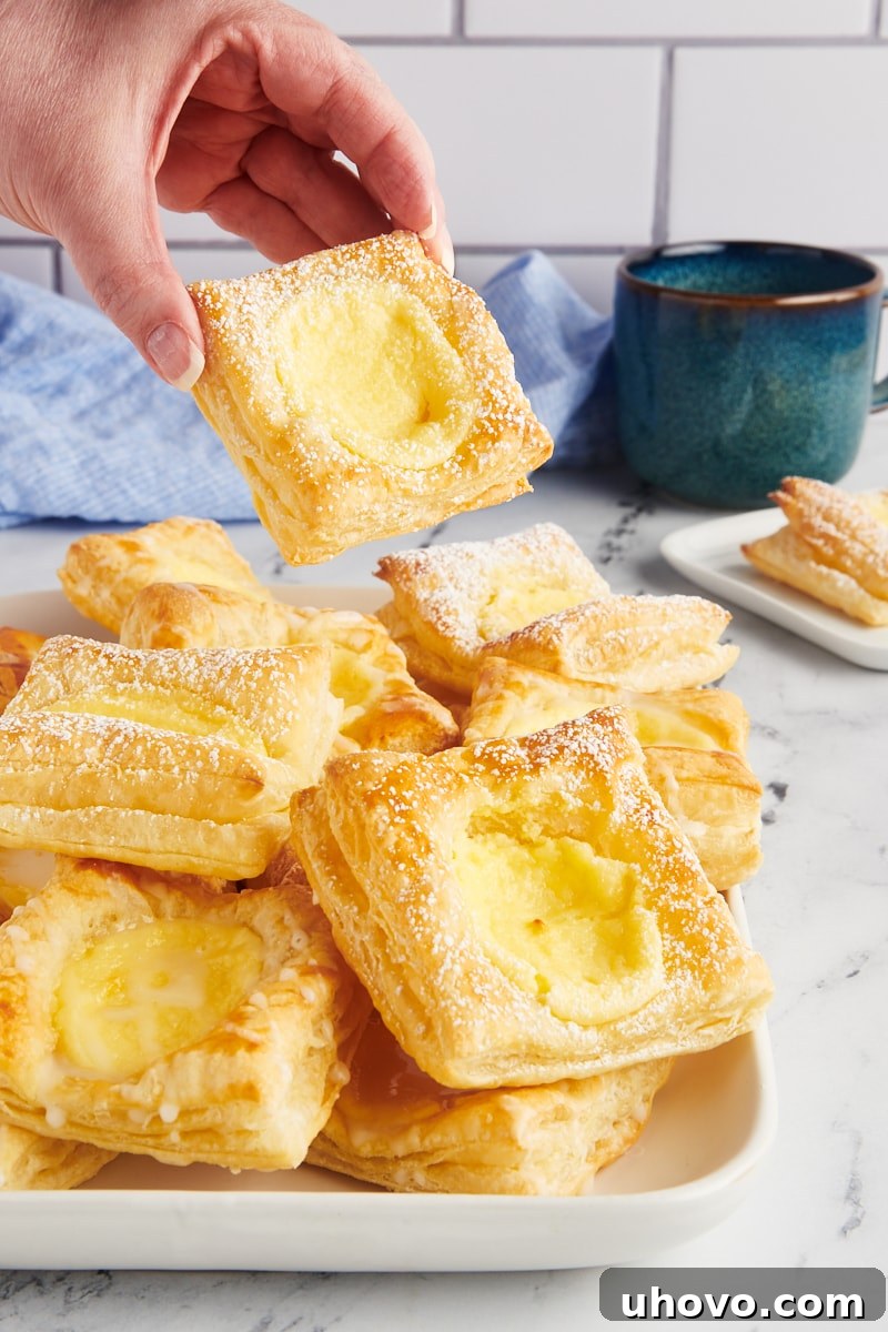 Hand lifting cheese danish from tray