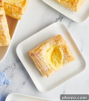 Overhead view of cheese danishes on square plates and tray
