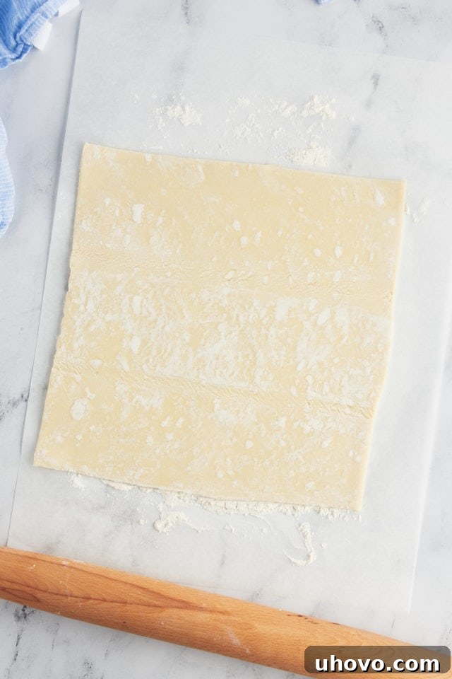 Overhead view of puff pastry sheet and rolling pin