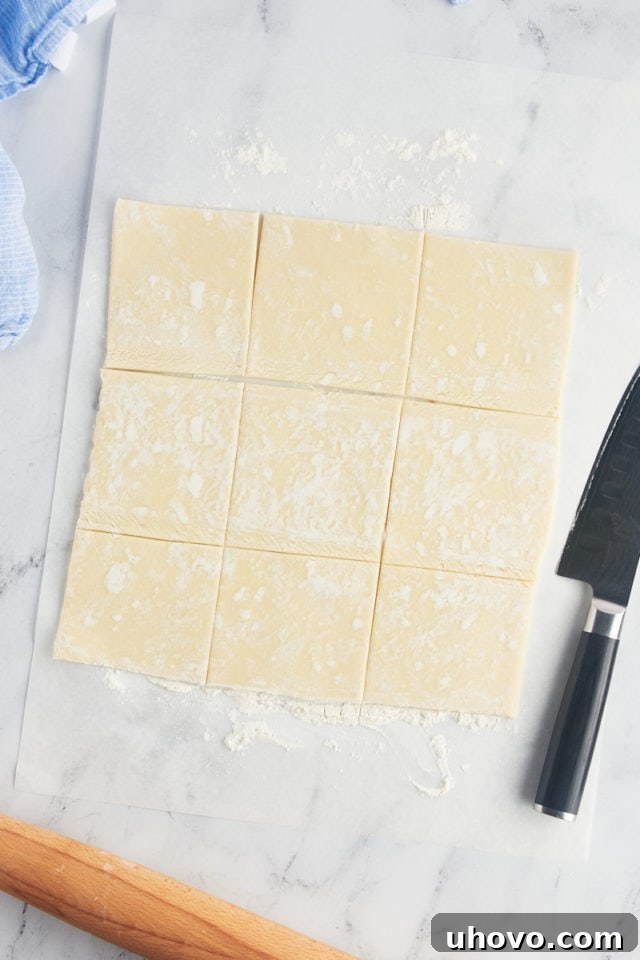 Overhead view of cut puff pastry dough with knife