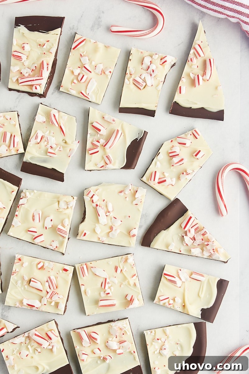 Overhead view of several artfully arranged pieces of peppermint bark resting on a elegant marble surface.