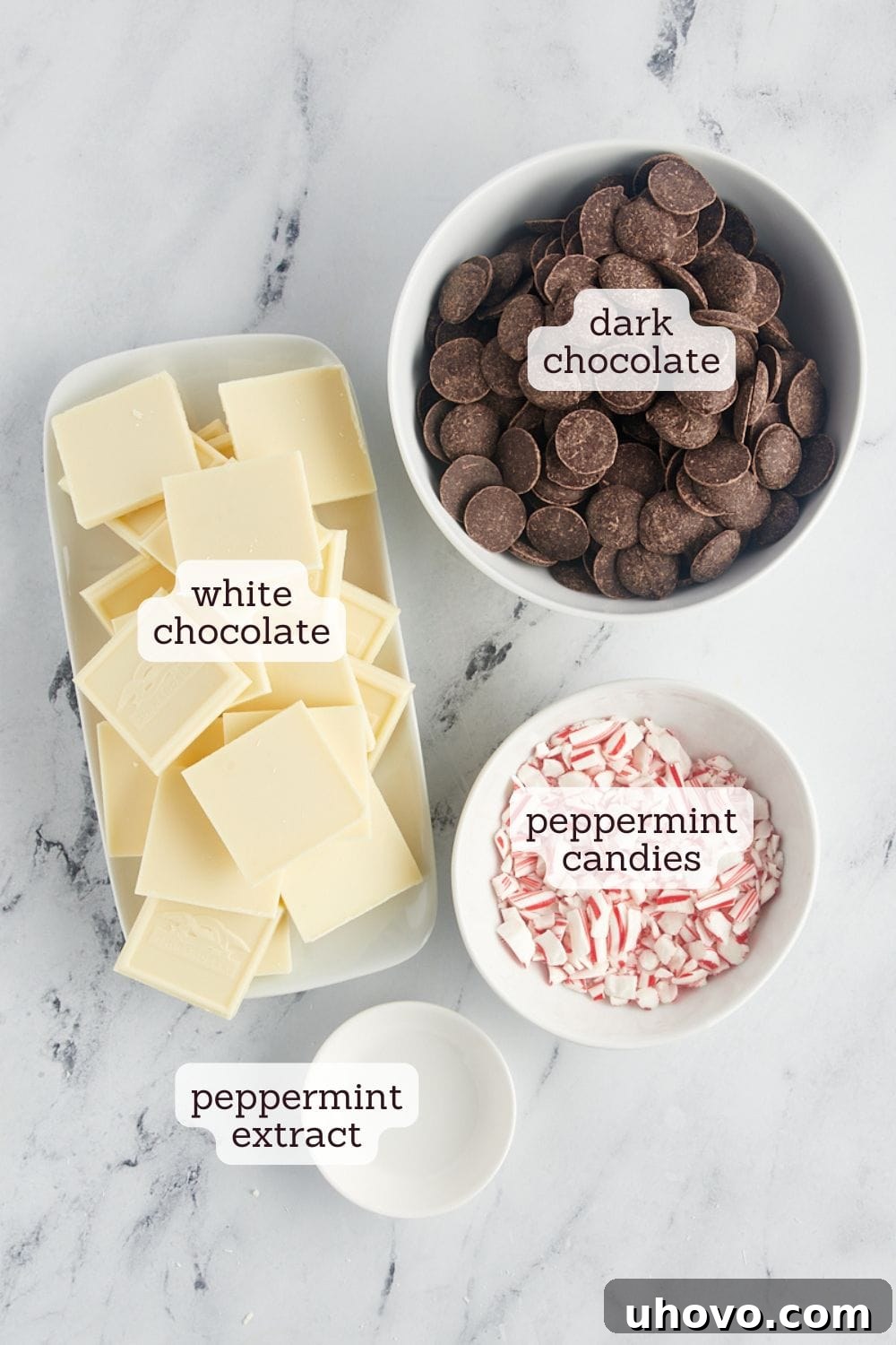 An overhead view showcasing the simple ingredients laid out for making peppermint bark, including chocolate, peppermint candies, and extract.