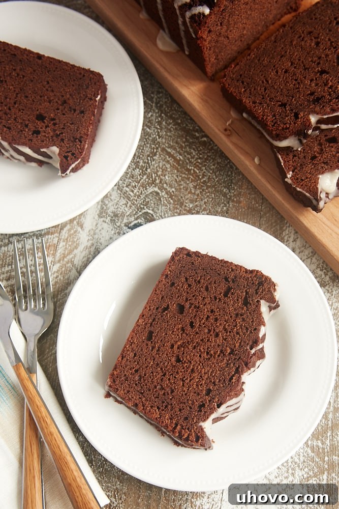 Close-up of a chocolate sour cream pound cake, showcasing its moist texture and the exquisite vanilla glaze drizzle.