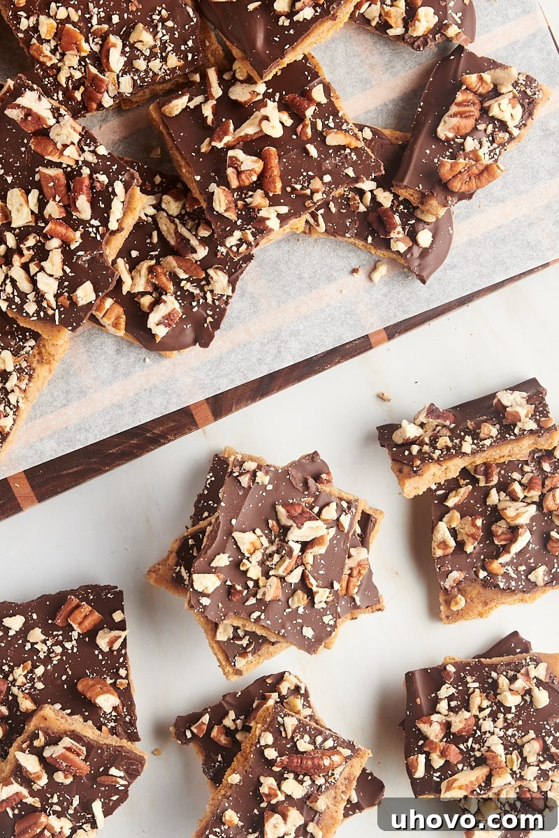 Overhead view of Graham Cracker Toffee pieces arranged beautifully on a rustic wooden board, with a marble countertop in the background.