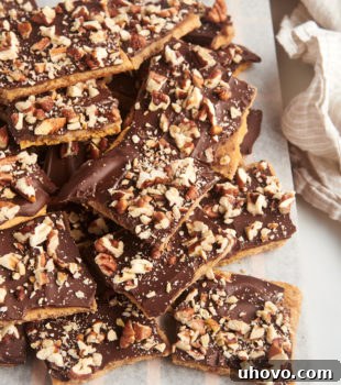 graham cracker toffee piled on a parchment-lined wooden board