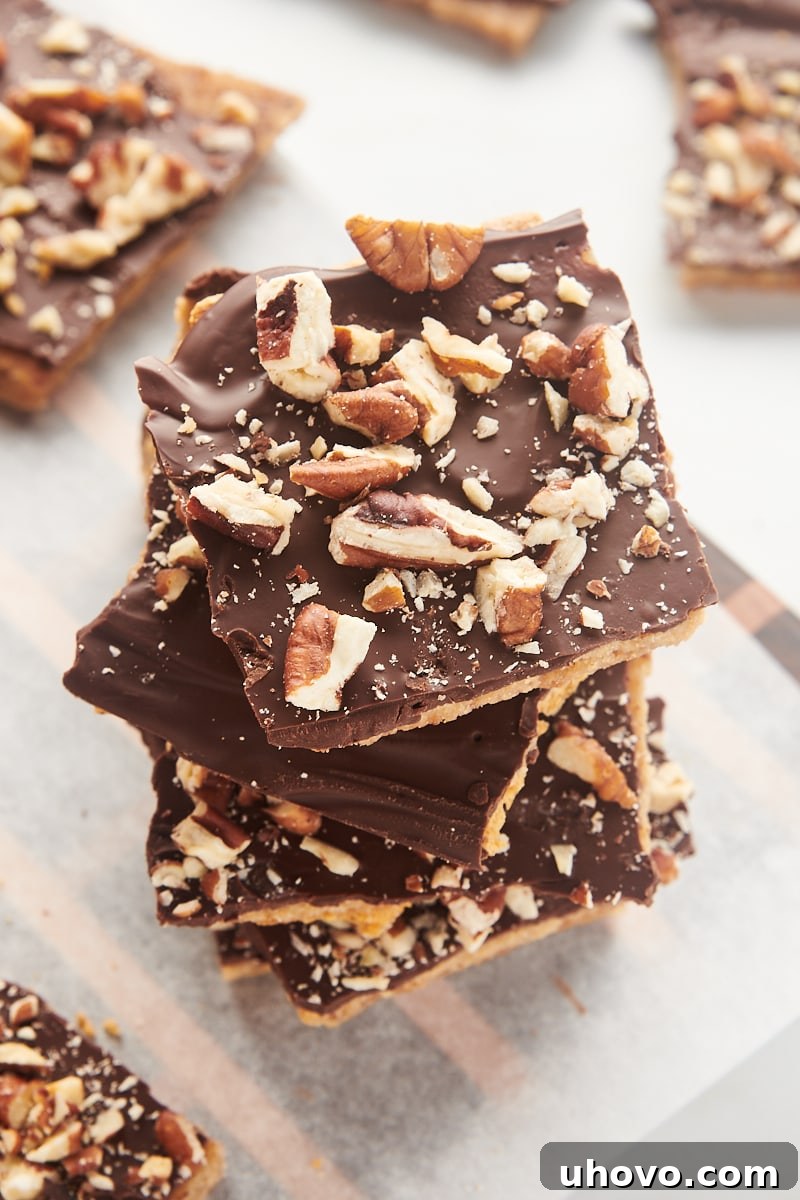 A perfectly stacked pile of Graham Cracker Toffee squares on parchment paper, ready to be enjoyed.